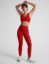 model wearing a red ribbed bra and red high-waisted ribbed leggings against a plain background.