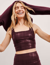 model wearing a red plaid foil printed square neck cropped tank top and matching leggings against a plain background.