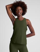 model wearing a green scoop neck tank top and leggings against a plain background.