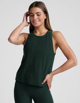 model wearing a green relaxed fit tank top and leggings against a plain background.