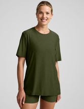 model wearing a green oversized men's t-shirt and biker shorts against a plain background.