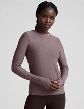 model wearing a mauve long-sleeve fitted crew neck top against a plain background.