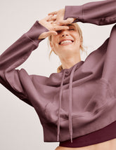 pink cropped pullover with a hood with drawcord and a kangaroo pocket.