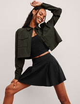 green cropped jacket with front chest cargo pockets and a collar at neckline.