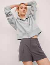 grey mid rise shorts with pockets and an elastic waistband with belt loops.