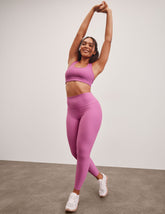 pink high-waisted midi length leggings.