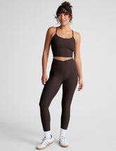 brown high-waisted midi length leggings with an overlapping front waistband.