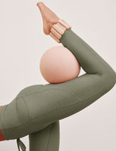 green high-waisted midi length leggings with pockets and a drawstring at waistband.