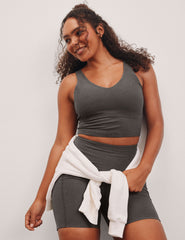 gray cropped length tank top with a front and back V neckline and self shelf bra. paired with high-waisted 5" inseam length biker shorts.