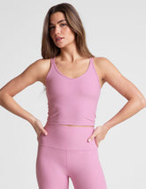 pink waist length, V neckline tank top with a self shelf bra and criss-cross strap back detail.