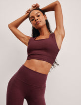 model is wearing a cropped square neck tank with thick straps.