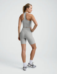 Woman wearing a gray athletic outfit on a white background.