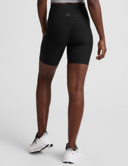 model wearing black 7" inseam biker shorts with pockets on a plain background.