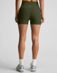 model is wearing green high-waisted 3" inseam shorts.