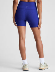 model is wearing blue high-waisted 5" inseam biker shorts.