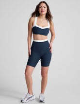 navy blue high-waisted biker shorts with a 5" inseam, waistband colorblock panels, and contrast piping detail on leg.