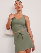 green mini skirt with a drawstring at waistband and pockets.