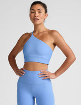 blue long line length bra with a one strap detail and an open back.