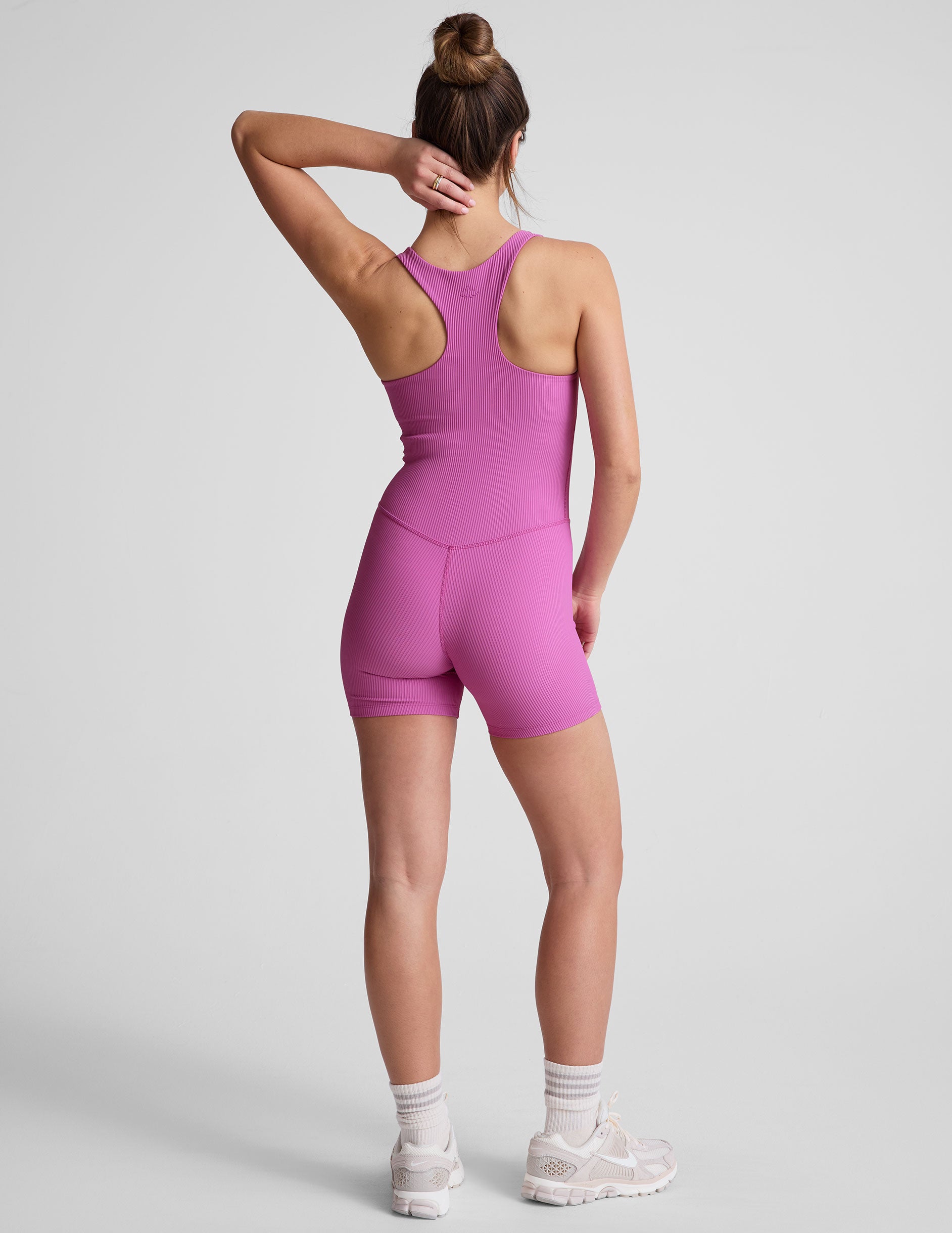 pink racerback 5" inseam tank jumpsuit with a front V neckline with overlapping detail. 