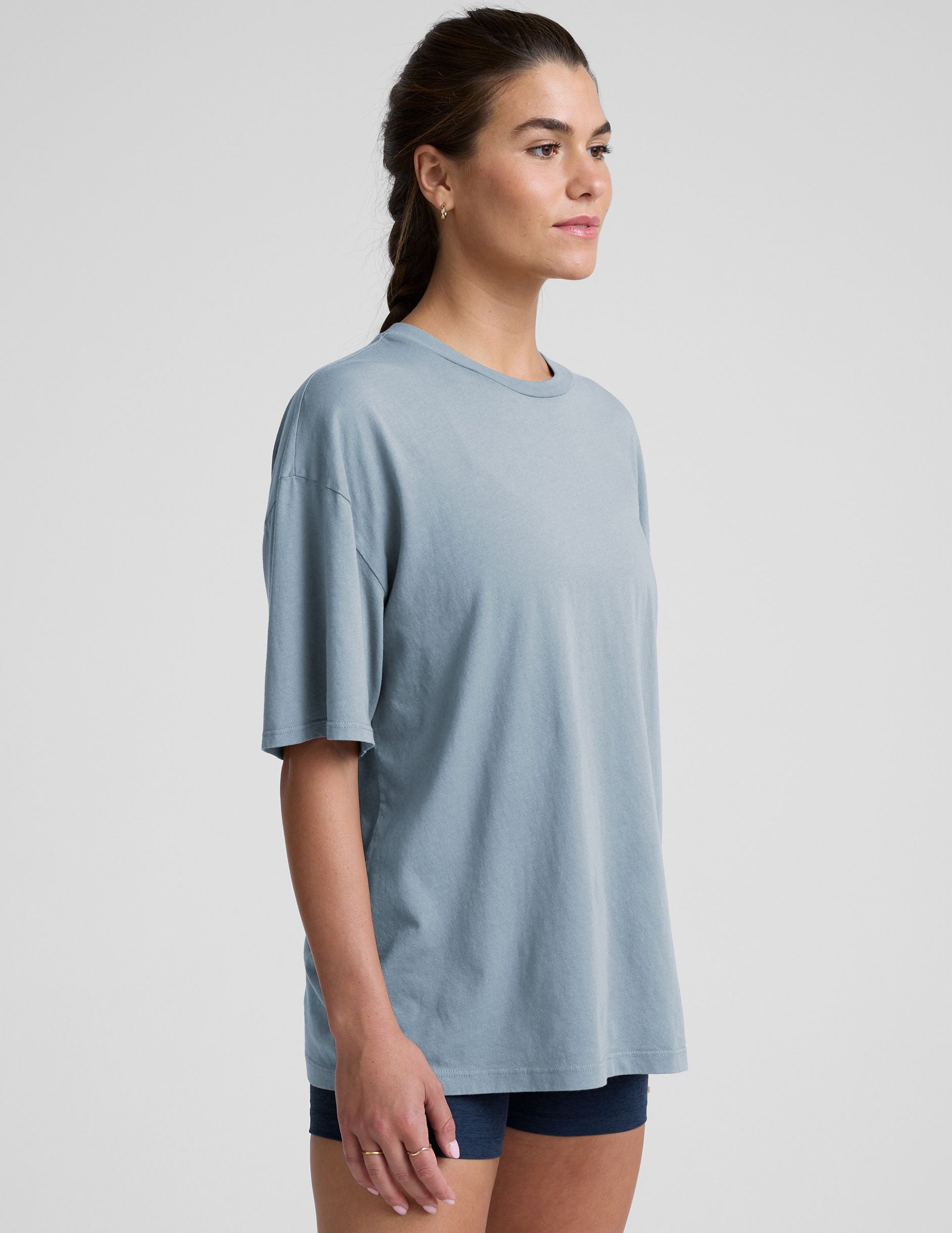 model wearing a light blue oversized cotton t-shirt and navy blue biker shorts against a plain background.