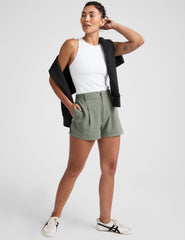 green shorts with an elastic waistband,  front zipper, button, and belt loops. 