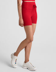 red high-waisted 5" biker shorts with pockets and a drawstring at waistband. 