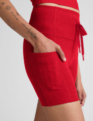 red high-waisted 5" biker shorts with pockets and a drawstring at waistband. 