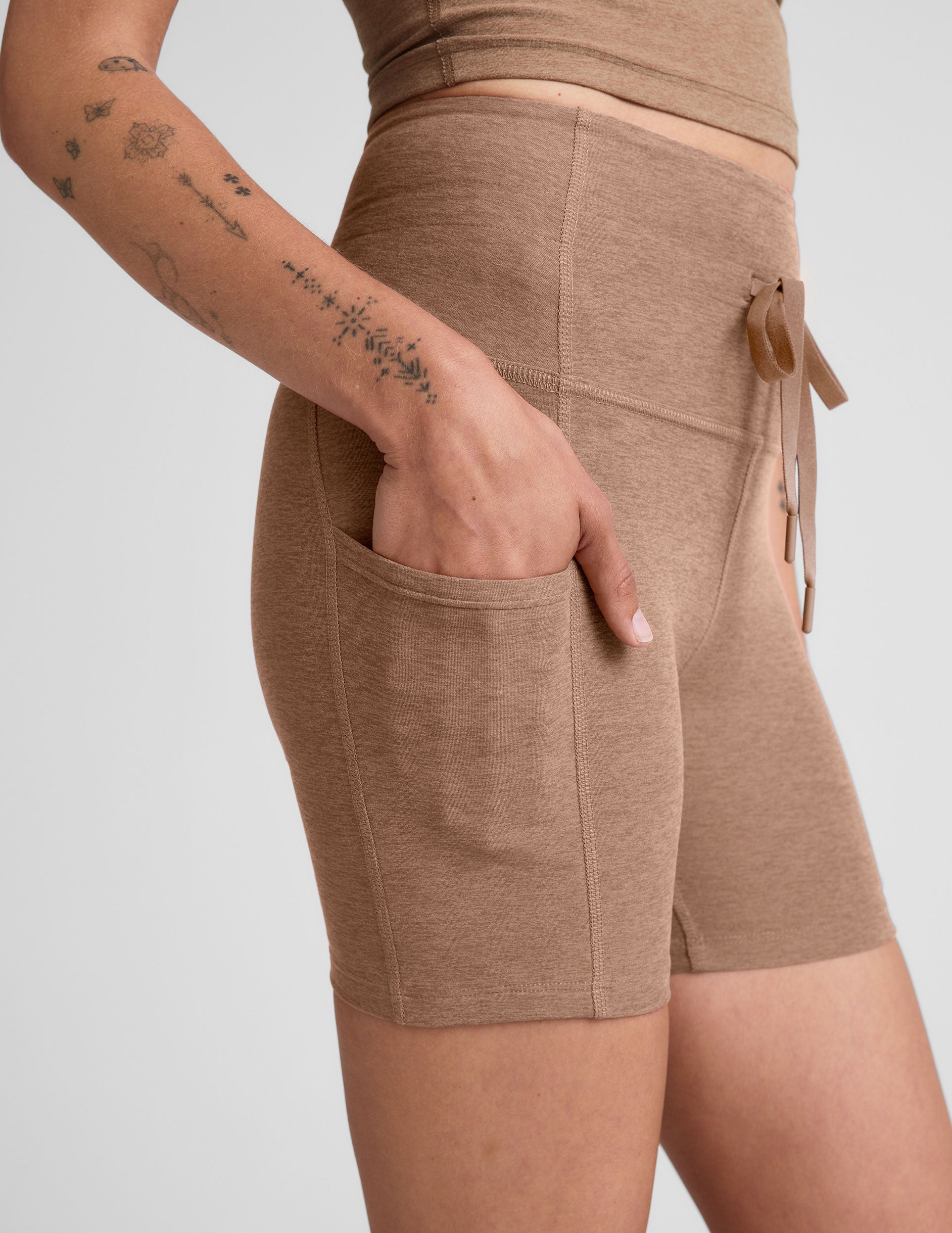 brown high-waisted 5" inseam biker shorts with pockets and a drawstring at waistband. 