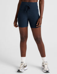 blue high-waisted 5" inseam biker shorts with pockets and a drawstring at waistband. 
