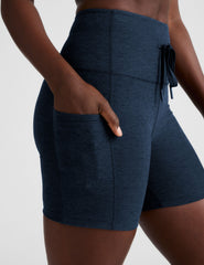 blue high-waisted 5" inseam biker shorts with pockets and a drawstring at waistband. 