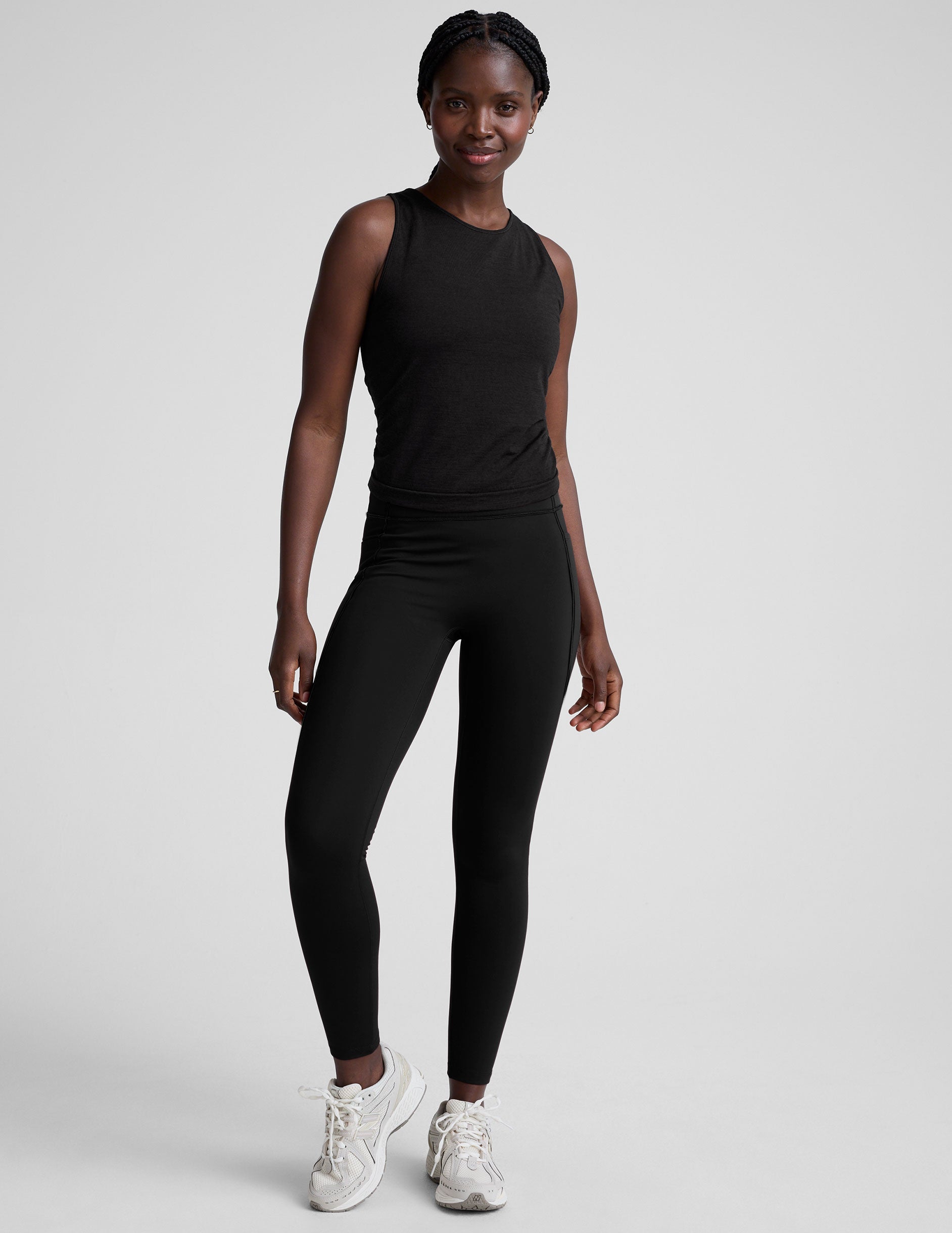 model wearing a scoop high neck racerback tank top against a plain background.